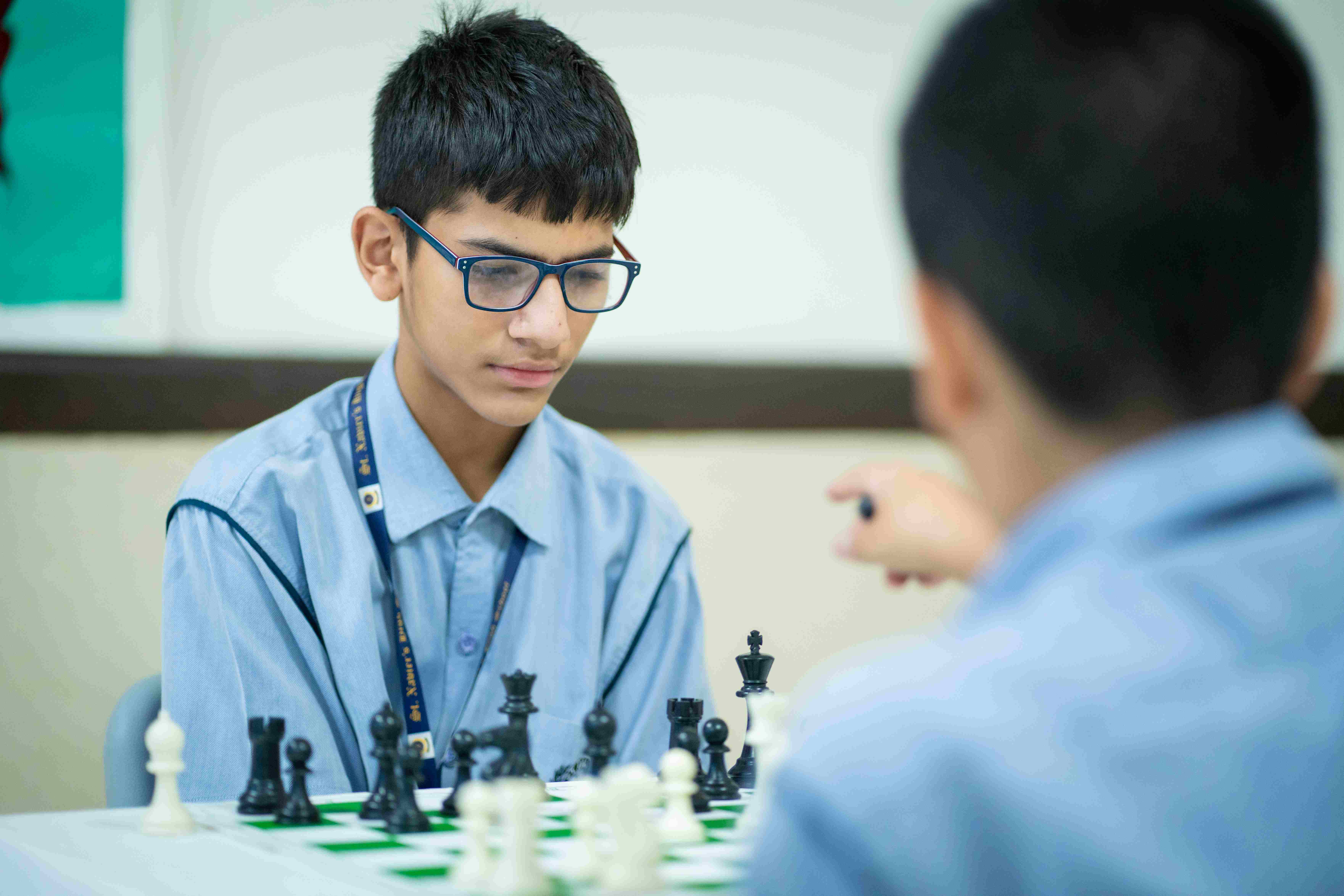 Two boys play chess at a top school in Gurgaon, showing sharp focus and strategic thinking.