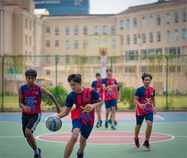 Young boys play basketball with energy and teamwork at the best CBSE school in Gurugram.