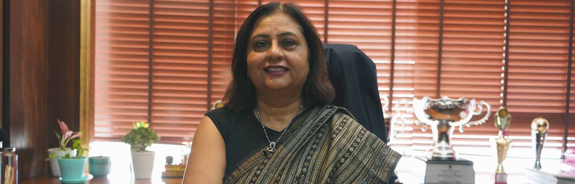 A woman in a sari at a desk, symbolizing grace at a top private school in Gurgaon.