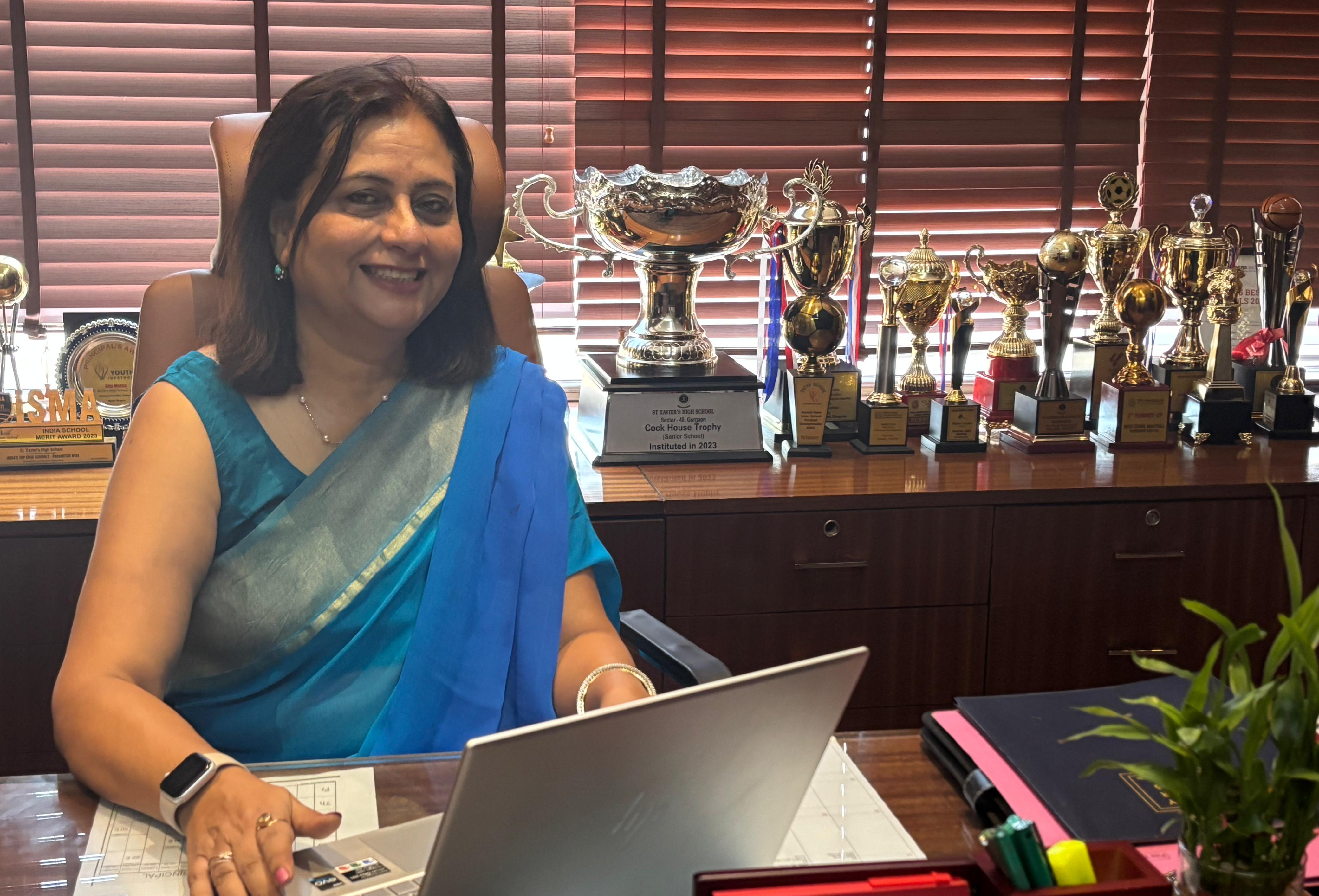 A woman in a sari at a desk, symbolizing grace at a top private school in Gurgaon.